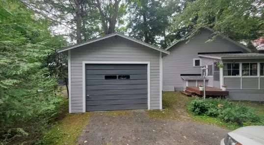 Grey garage with a dark garage door, freshly painted