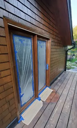 Patio door masked with plastic and tape during an exterior job